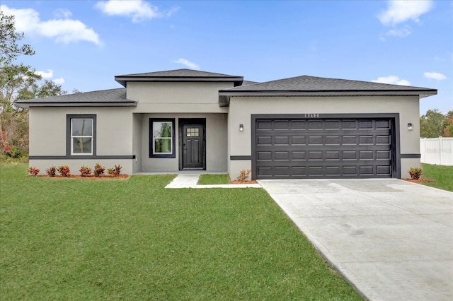 prairie-style home featuring a garage and a front yard