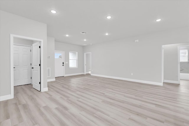 unfurnished living room with a wealth of natural light and light wood-type flooring