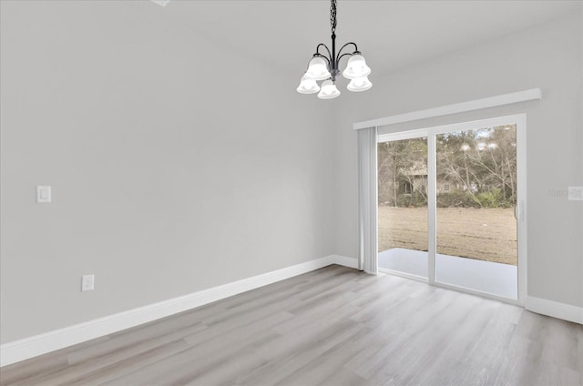 unfurnished dining area featuring an inviting chandelier and light hardwood / wood-style floors