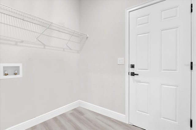 clothes washing area featuring washer hookup and light hardwood / wood-style flooring