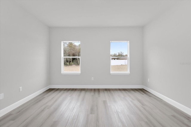 spare room featuring light hardwood / wood-style floors and a healthy amount of sunlight