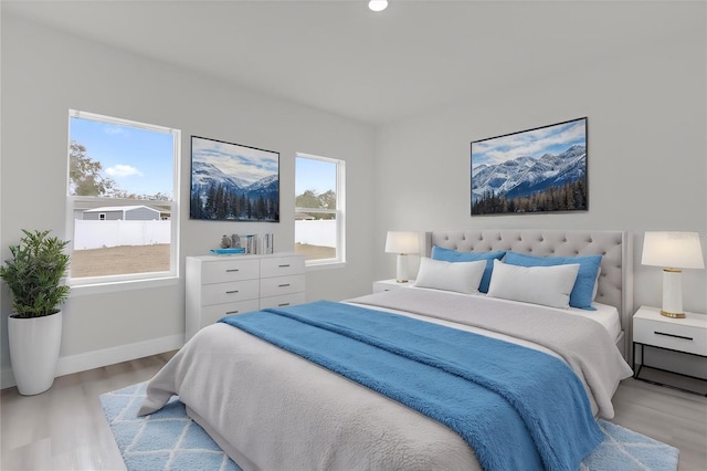 bedroom featuring multiple windows and light hardwood / wood-style flooring