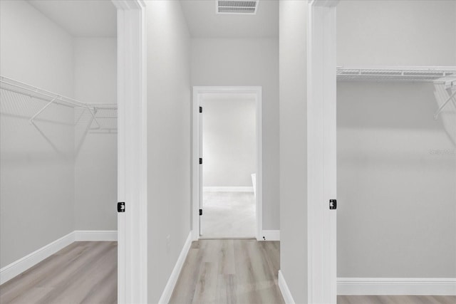 walk in closet featuring light hardwood / wood-style flooring