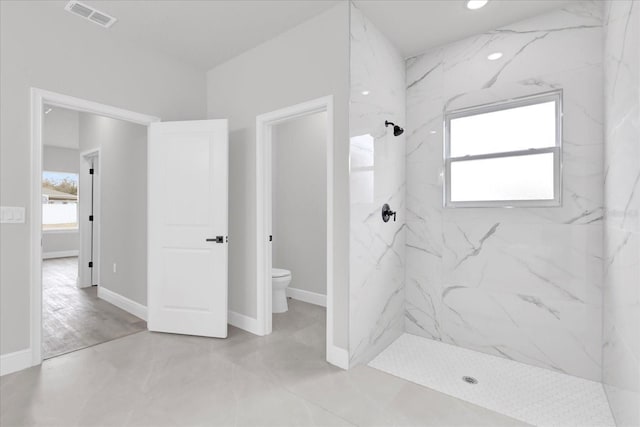 bathroom featuring toilet and tiled shower