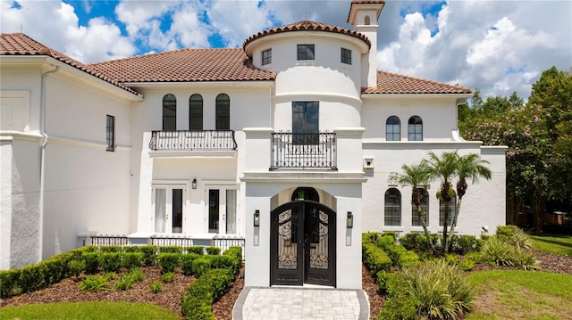 mediterranean / spanish house with a balcony and french doors