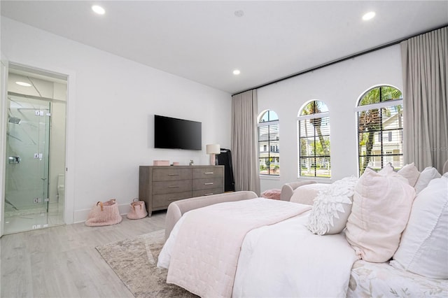 bedroom featuring ensuite bathroom and light hardwood / wood-style floors