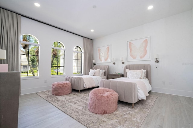 bedroom with multiple windows and light wood-type flooring