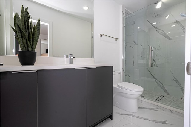 bathroom with vanity, a shower with shower door, and toilet