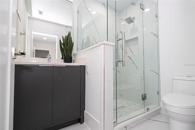 bathroom featuring vanity, a shower with shower door, and toilet