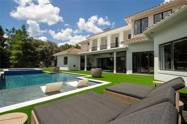 view of swimming pool with ceiling fan and a lawn