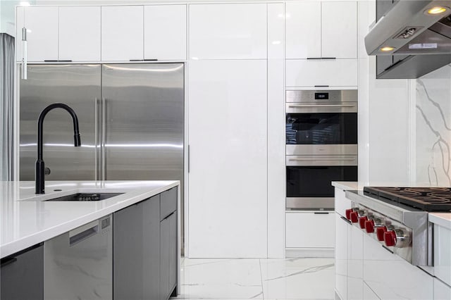 kitchen with extractor fan, appliances with stainless steel finishes, and white cabinets