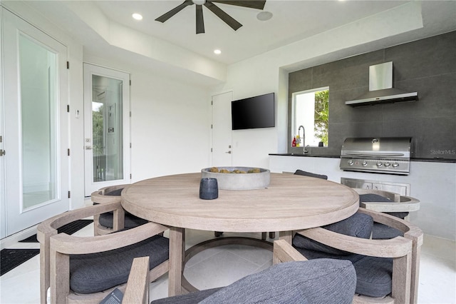 dining area featuring ceiling fan, sink, and light tile patterned floors