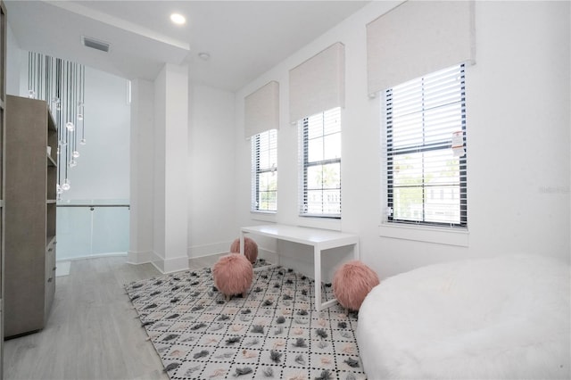 bedroom featuring multiple windows and light wood-type flooring