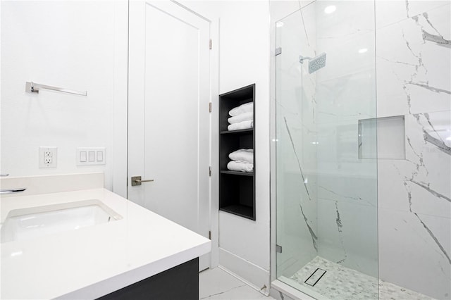 bathroom featuring a tile shower and vanity