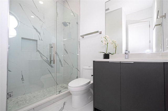 bathroom featuring vanity, a shower with shower door, and toilet