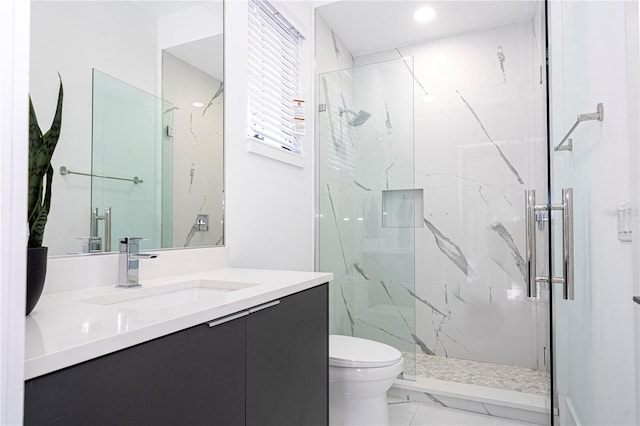 bathroom with an enclosed shower, vanity, and toilet