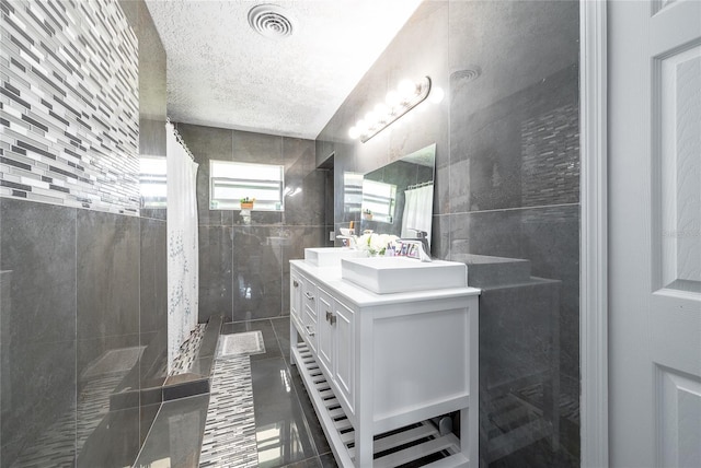 5006 Monet Ave, Belle Isle, FL 32812 - bathroom with tile patterned flooring, vanity, tile walls, and a textured ceiling