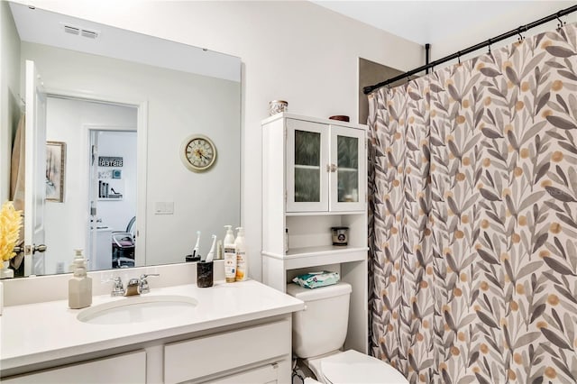 bathroom featuring vanity, toilet, and a shower with shower curtain