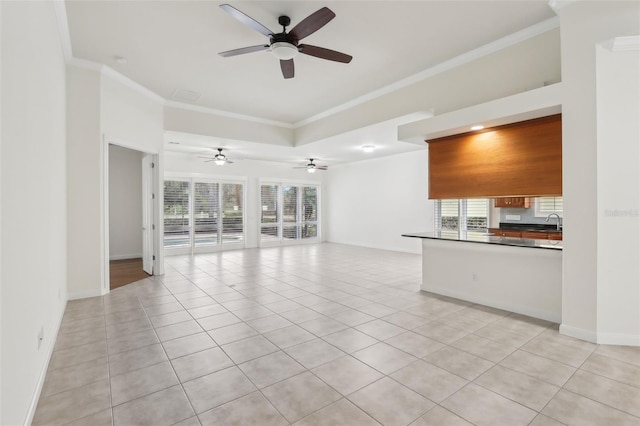 unfurnished living room with ornamental molding, sink, and light tile patterned floors