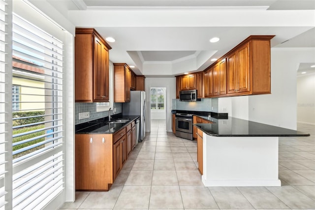 kitchen featuring appliances with stainless steel finishes, a raised ceiling, light tile patterned floors, and dark stone countertops