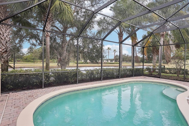 view of swimming pool with a patio, a water view, and glass enclosure