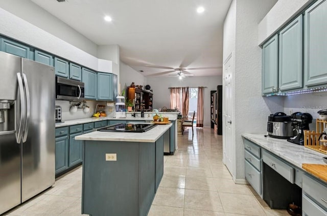 kitchen featuring blue cabinetry, ceiling fan, stainless steel appliances, a center island, and light tile patterned flooring