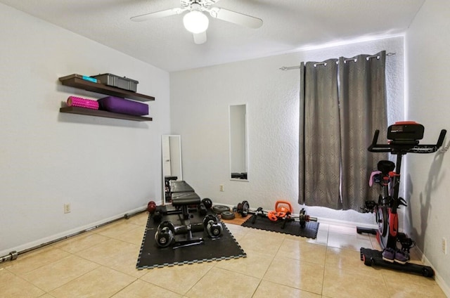 workout area featuring a textured ceiling, ceiling fan, and light tile patterned flooring