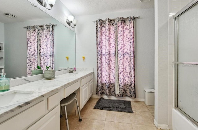 bathroom featuring vanity, tile patterned floors, shower / bath combination with glass door, and a textured ceiling