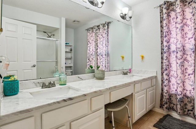 bathroom featuring tile patterned flooring, vanity, and a textured ceiling