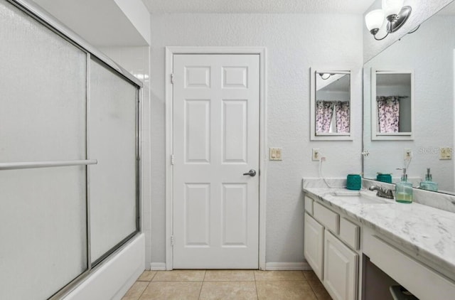 bathroom with tile patterned floors, shower / bath combination with glass door, and vanity