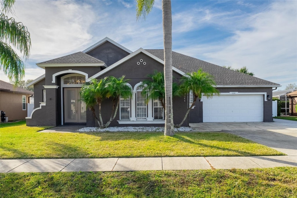 view of front of home with a garage and a front lawn