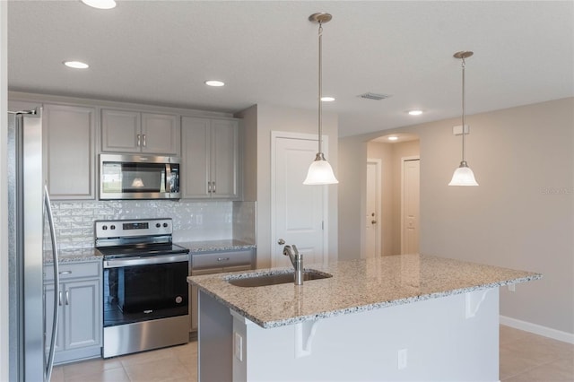 kitchen featuring tasteful backsplash, stainless steel appliances, decorative light fixtures, and sink