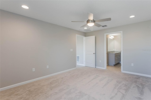 unfurnished bedroom featuring ceiling fan, connected bathroom, and light carpet