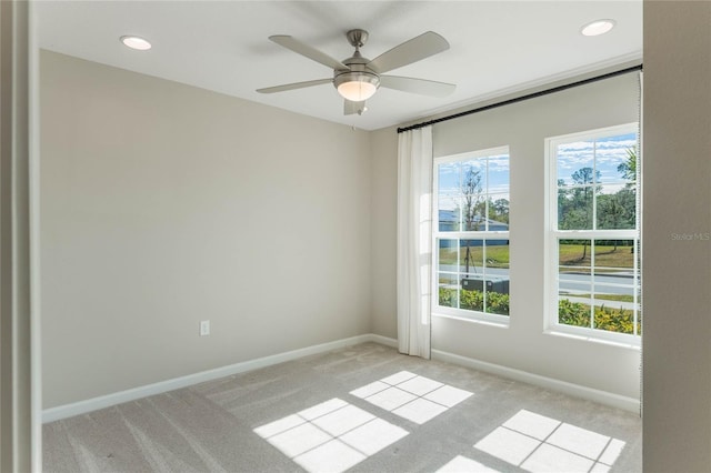 unfurnished room featuring plenty of natural light, light carpet, and ceiling fan