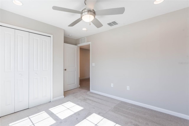 unfurnished bedroom with light carpet, a closet, and ceiling fan