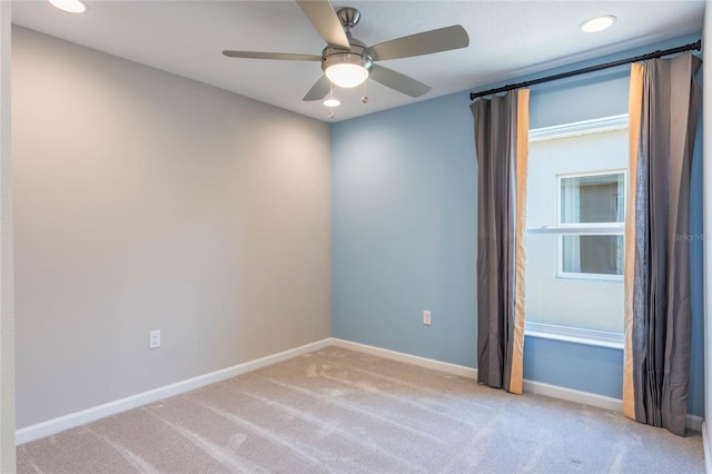 unfurnished room with light colored carpet and ceiling fan