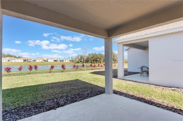 view of yard with a water view and a patio