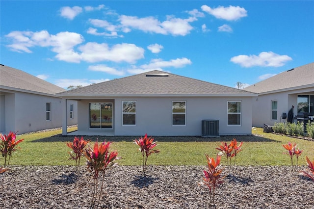 rear view of house featuring cooling unit and a lawn