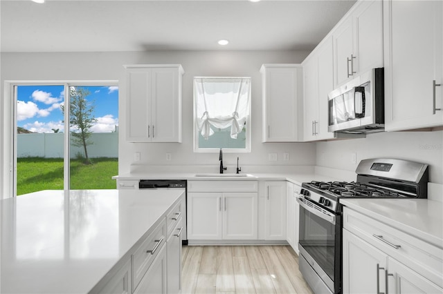 332 Bow Ln, Haines City, FL 33844 - kitchen featuring stainless steel appliances, white cabinets, light countertops, and a sink