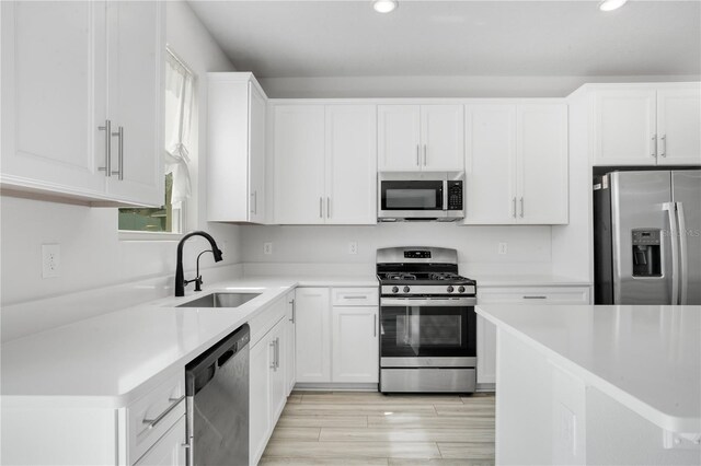 332 Bow Ln, Haines City, FL 33844 - kitchen featuring stainless steel appliances, white cabinets, light countertops, and a sink