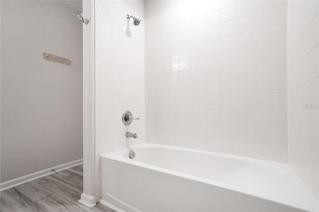 332 Bow Ln, Haines City, FL 33844 - bathroom featuring tub / shower combination, wood finished floors, and baseboards