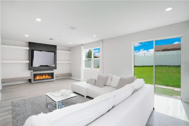 332 Bow Ln, Haines City, FL 33844 - living room featuring a fireplace, wood finished floors, visible vents, and recessed lighting