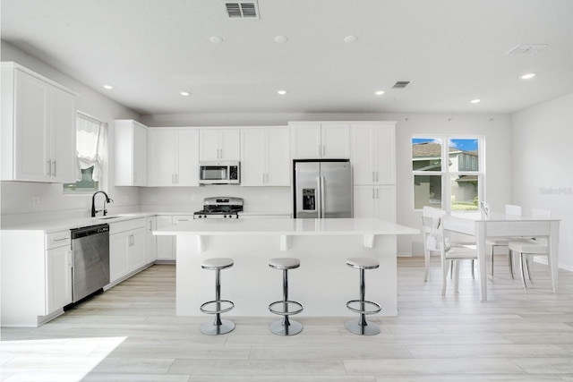 332 Bow Ln, Haines City, FL 33844 - kitchen with a sink, appliances with stainless steel finishes, a kitchen island, and a breakfast bar