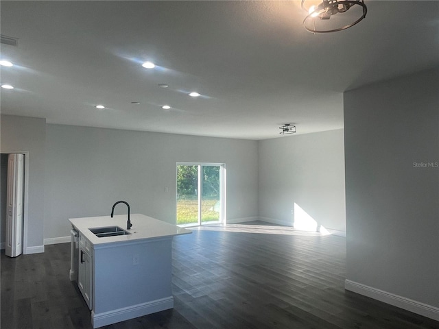 kitchen featuring sink, white cabinetry, stainless steel dishwasher, dark hardwood / wood-style flooring, and an island with sink