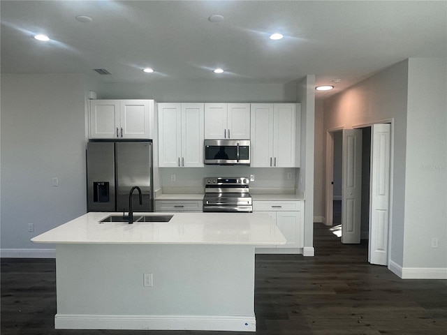 kitchen featuring white cabinetry, stainless steel appliances, a kitchen island with sink, and sink