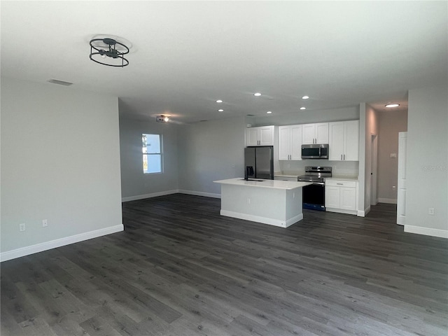 kitchen featuring white cabinetry, stainless steel appliances, dark hardwood / wood-style floors, and a center island