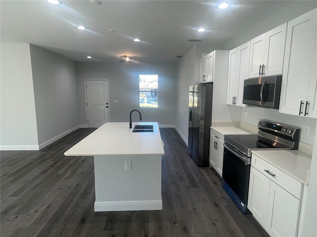 kitchen with sink, dark wood-type flooring, appliances with stainless steel finishes, a kitchen island with sink, and white cabinetry