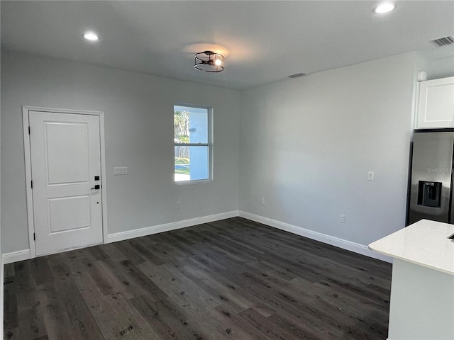 unfurnished dining area with dark wood-type flooring