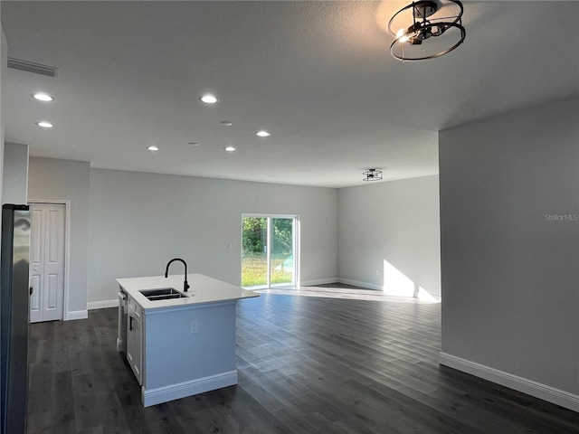 kitchen with white cabinetry, sink, dark wood-type flooring, and a center island with sink