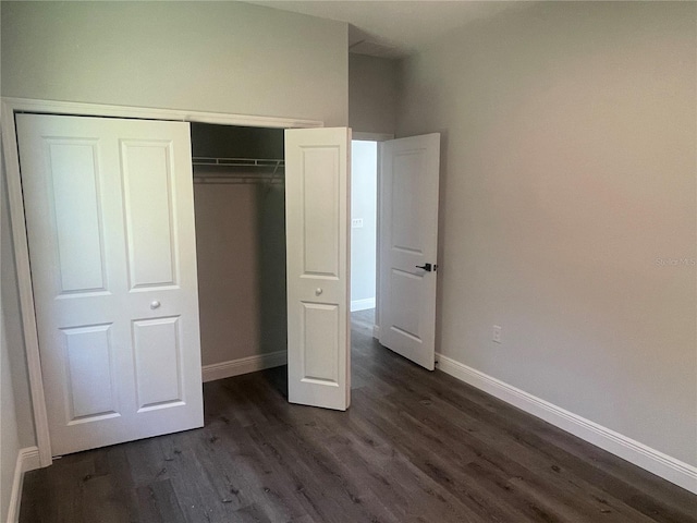 unfurnished bedroom featuring dark hardwood / wood-style floors and a closet